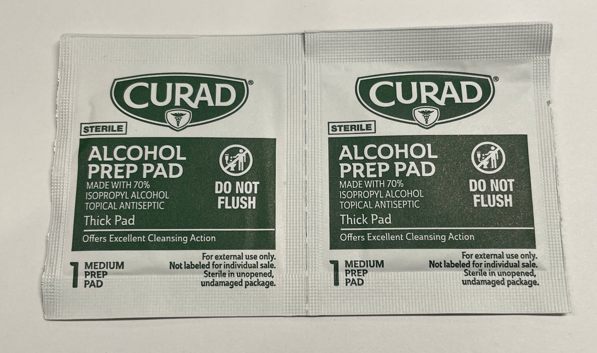 Two Curad Sterile Alcohol Prep Pad single-use packets on a plain white surface.